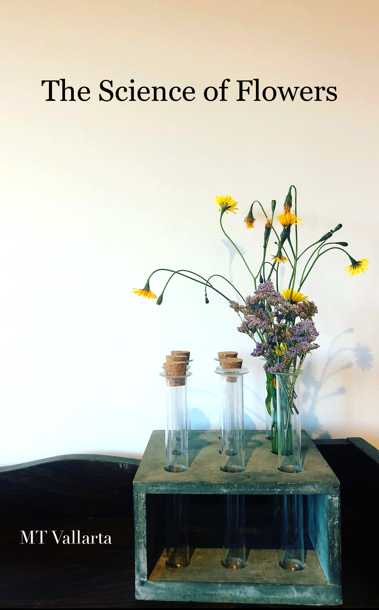 The cover for The Science of Flowers by MT Vallarta. A photo of small purple and yellow flowers coming out of scientific vials. The title is centered toward the top, author name bottom left.